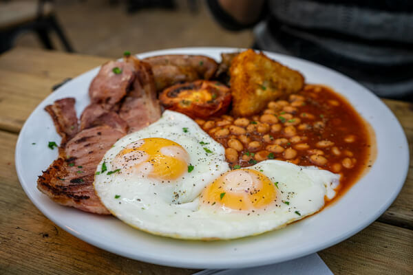 English breakfast of eggs, baked beans, bacon and bread